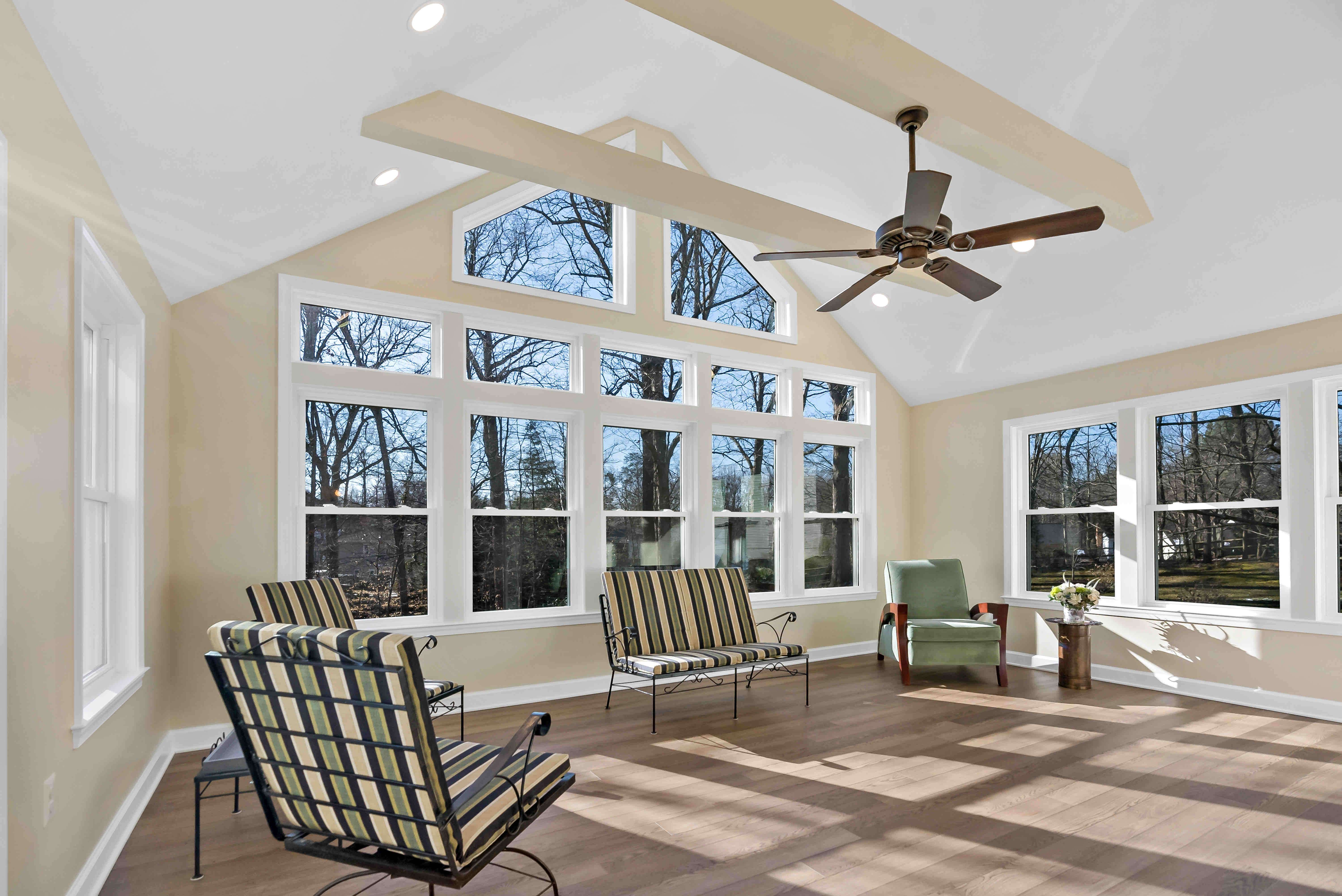 Sunroom with large windows and beige walls and hard wood floors