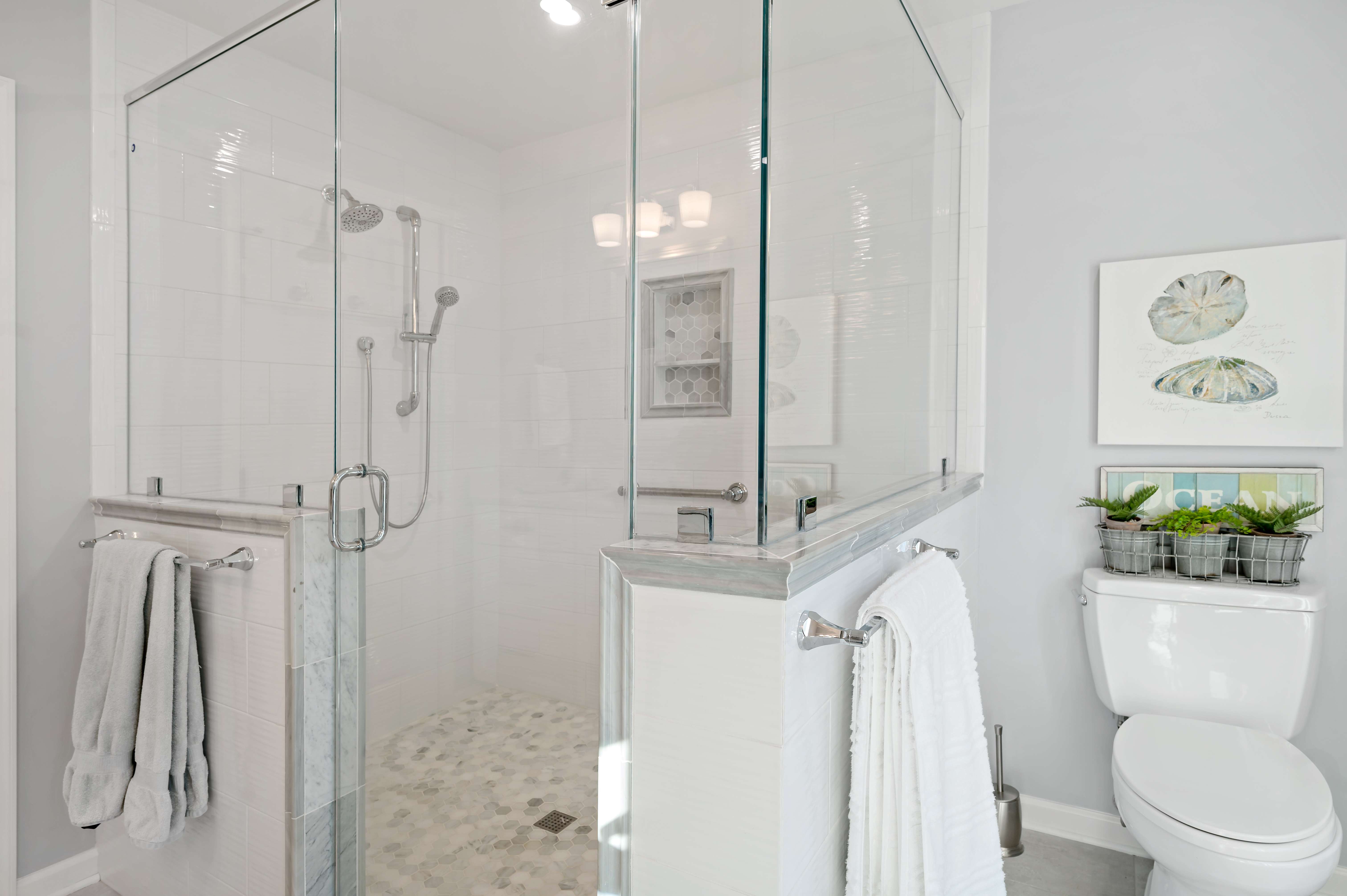 White bathroom with large walk-in shower and glass walls