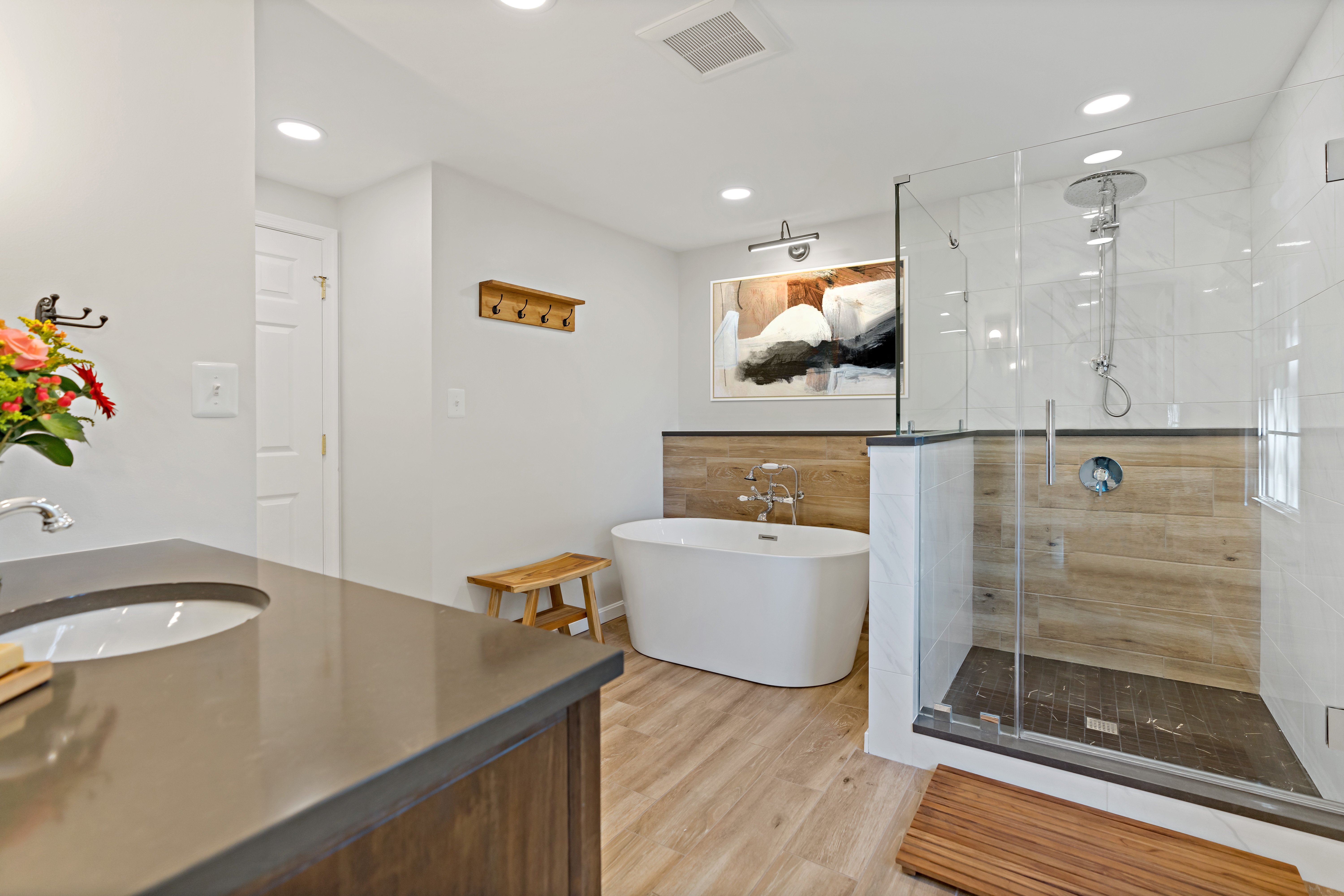 Scandinavian style bathroom with light wood accents, sleek design, and modern bathtub and shower