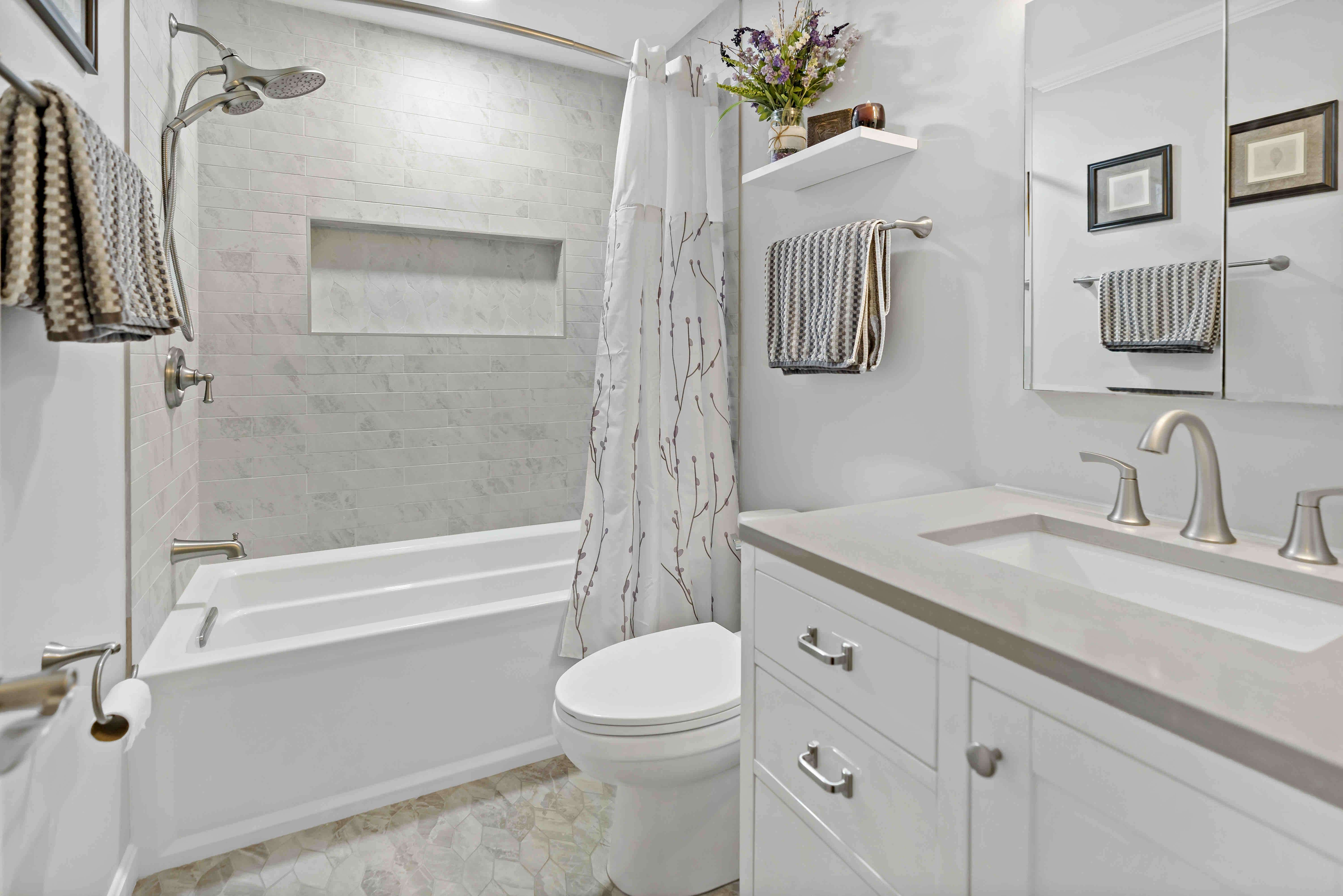 Neutral brown and white bathroom with bathtub shower and curtain