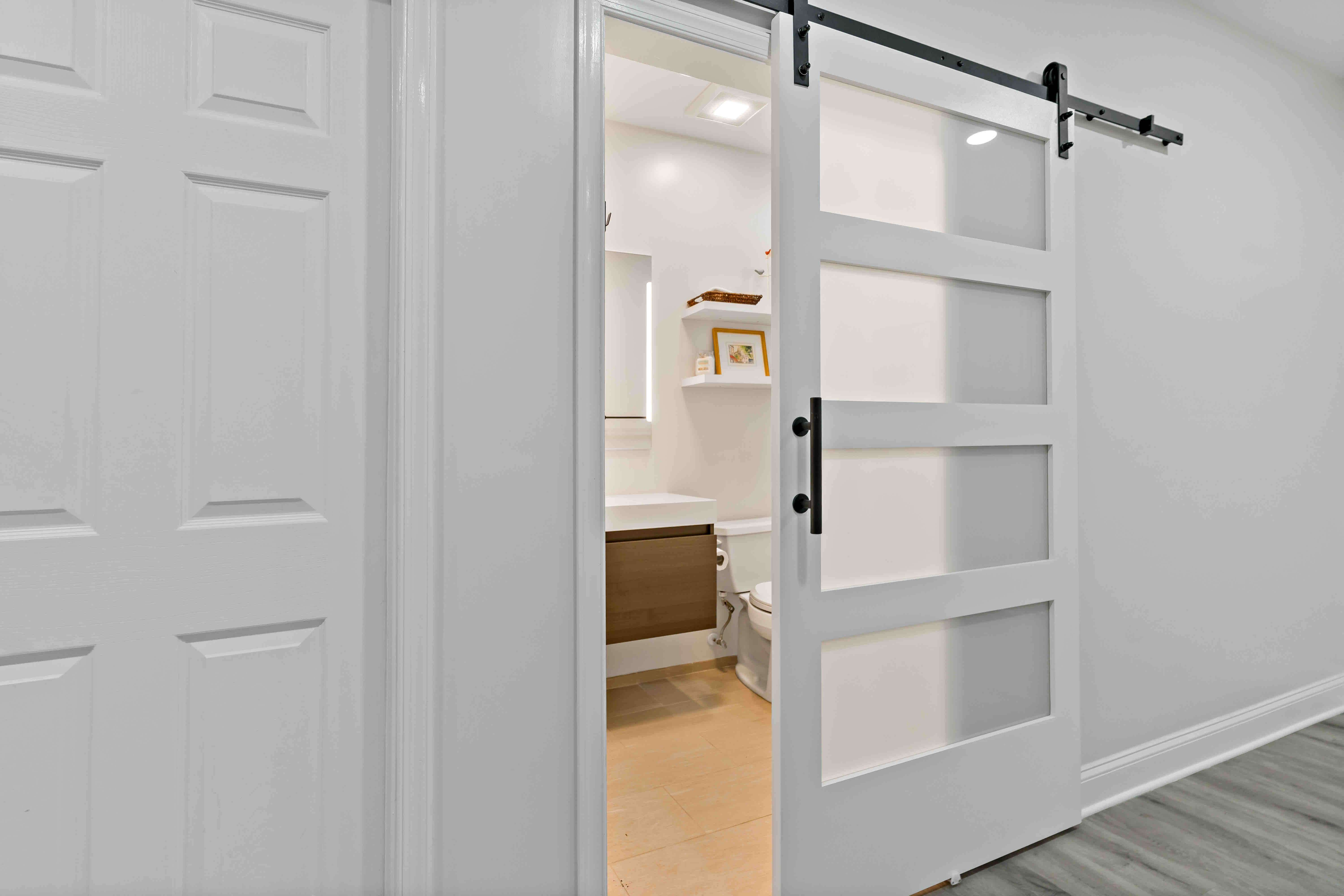 White sliding barn door to enter bathroom in basement