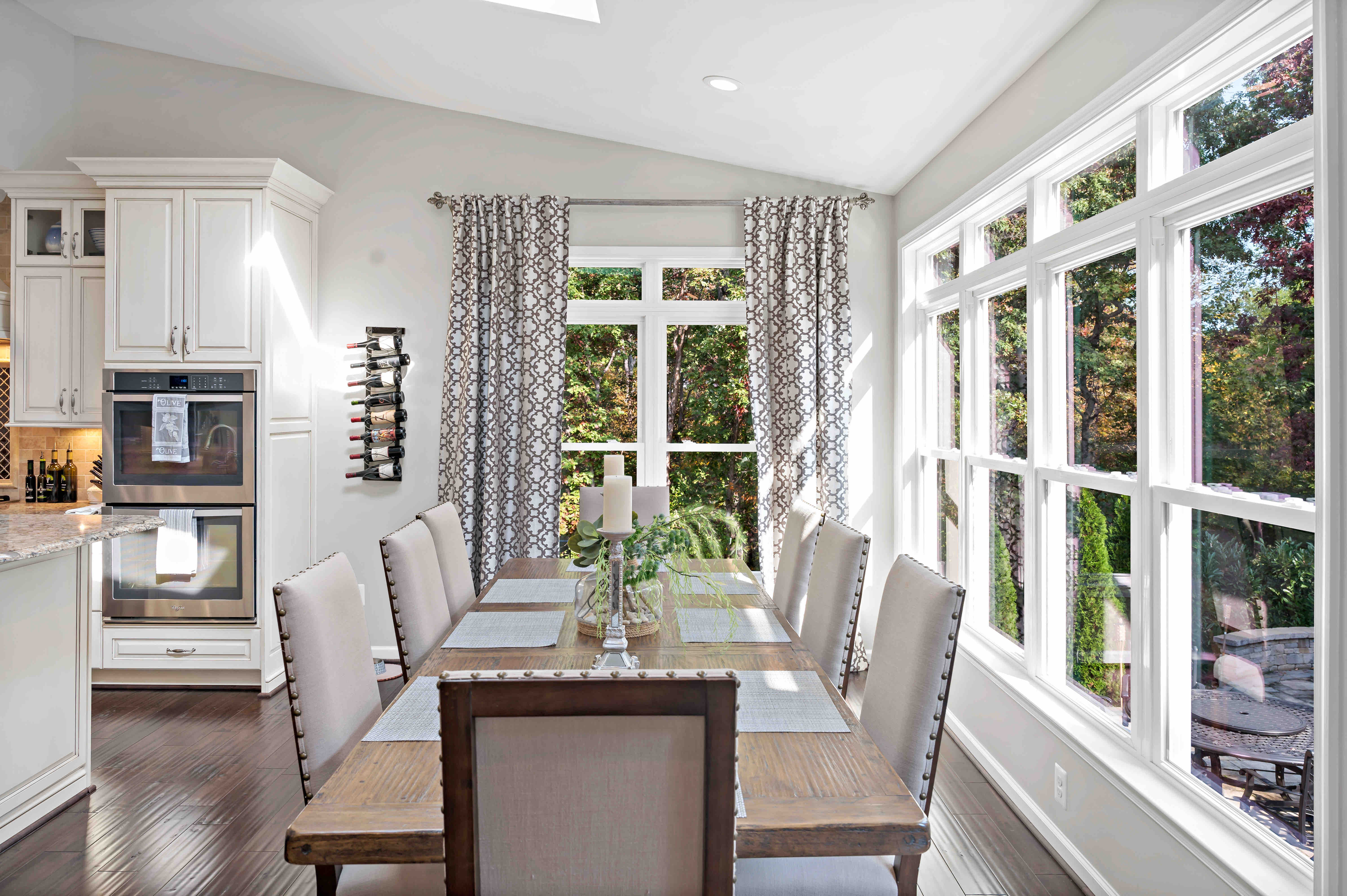 Brown and beige aesthetic in dining room with curtains and large windows for backyard views